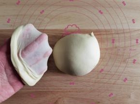 将打好面团取出，双手握住面团折叠收圆，切开一块，慢慢扯出薄膜，无需手套膜的程度。面团收圆，放入干净盆中，盖保鲜膜，温暖处27度进行第一次发酵，大约60分钟左右。