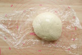 折叠按压排气，双手握住面团，逆时针滚圆后盖上保鲜膜，松弛15分钟。