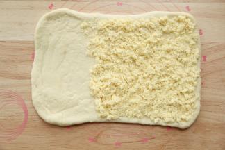 松弛好的面团，擀开成长方形，长40公分，宽20公分左右，翻面，整理。在2/3处铺上椰蓉奶酥馅料。