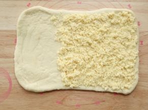 松弛好的面团，擀开成长方形，长40公分，宽20公分左右，翻面，整理。在2/3处铺上椰蓉奶酥馅料。