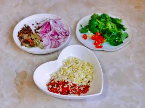 洋葱切丝，小米辣切段，香菜洗净切段，大蒜去皮切碎与芝麻，辣椒碎加入器具中。