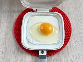 把三明治烤盘预热三分钟，盘里刷一层油，然后磕入一个鸡蛋。