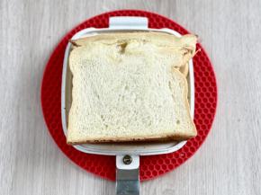 再盖上另一片吐司片，然后扣好三明治烤盘，分离式的烤盘，厚薄可以随心切换，即使夹了这么多的食材，还是可以轻松得扣上。