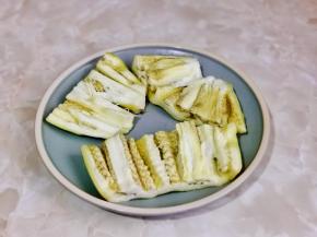 蒸软的茄子对半切开，中间划两刀。