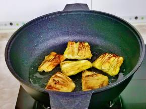 起油锅放入茄子中小火煎至两面金黄。