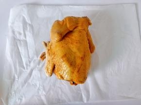 腌制好的三黄鸡用油纸先包一层。