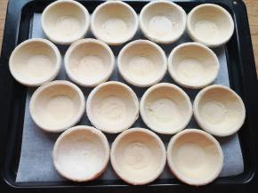 蛋挞皮提前解冻，摆在烤盘里。 