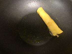 趁蛋黄还没完全凝固的时候，从一端卷起成蛋黄卷。