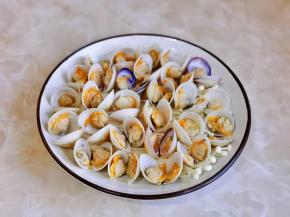 把开口的蛤蜊摆在金针菇上。