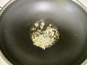 锅里下油烧热，下入剁碎的蒜末爆香。