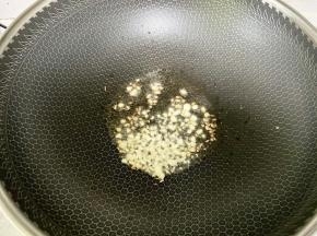 锅里下油烧热，下入剁碎的蒜末爆香。