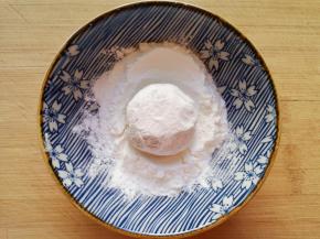 取一个土豆球放入玉米淀粉里面打个滚。