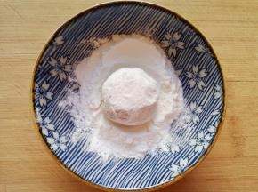 取一个土豆球放入玉米淀粉里面打个滚。