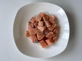 三文鱼洗净块，加盐和黑胡椒粉，用手轻轻刷匀，腌制15分钟。