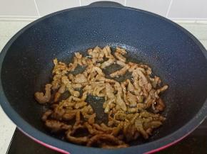锅里放少许食用油，油热倒入肉丝大火爆炒。