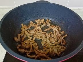 锅里放少许食用油，油热倒入肉丝大火爆炒。