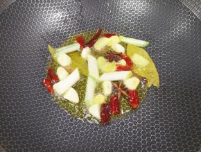 炒锅内倒适量的菜籽油烧热，下入葱姜蒜、香叶、八角、桂皮和干红辣椒炒香。