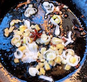 锅中倒入底油加热放入花椒和八角炸香再放入葱姜蒜爆香