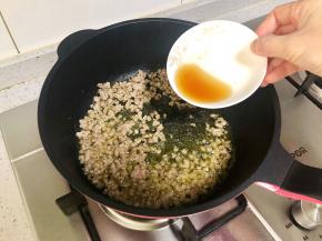 锅中热油，下肉末炒至酥香，加入料酒去腥。