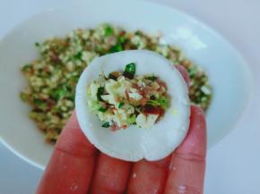 取一个小的糯米团，揉圆压扁包上馅料。