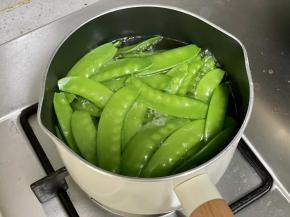 把荷兰豆下入沸水中焯烫30秒，然后捞出沥水。很多人省去了这一步，所以炒出来不够翠绿，也不好吃。