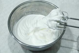 继续打到细密小泡，加入1/3糖；打到蛋白略带纹路，加入最后的糖。打到提起打蛋头呈现大弯钩（湿性发泡），转低速再打几圈，整理大气泡。