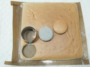 蛋糕胚烤完后取出，振出热气后，转移到冷凉架上冷凉，盖上油纸防止表皮被吹干。微温后可以倒扣，撕掉底部的油布！毛巾卷！冷凉好的蛋糕胚用圆形模具扣出蛋糕片。可以组装8个小贝。