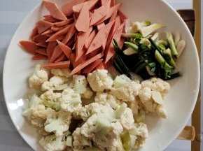 花菜掰成小朵洗净沥干水分，火腿肠切成块，蒜苗切成段备用！