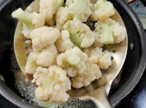 水开，放入花菜焯水一分钟左右至断生！捞出沥干水分备用！