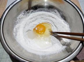 打入一个鸡蛋，再加适量水，蛋液和水的总量不超过65克。