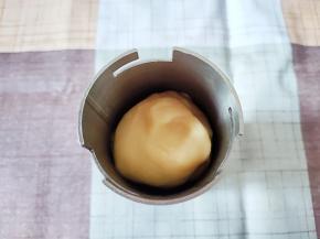 第二天一早，先把面团拿出回温到室温，然后搓成大圆条，塞进压面枪的压面桶里。