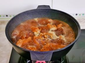 压好后的猪蹄连汤汁倒入炒锅中大火收汁。