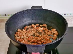 起热锅倒入肉丁煸炒至变色。