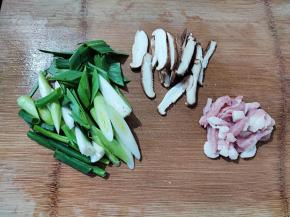 准备配菜。五花肉、香菇和青蒜都洗干净，切好。