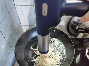 水烧开后，将面团搓成圆柱，塞入面条枪的压面桶中，组装好压面枪，将面条直接压进锅里。