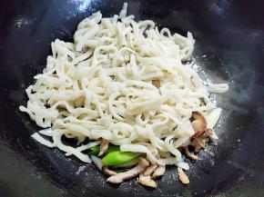 将面条倒入翻炒至每一根面条都裹上油，如果这时候油太少，可以再加一点油。