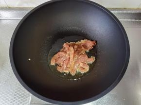 牛肉腌制好，干净不粘锅中，倒入3勺玉米油，开大火热油，倒入腌制好的牛肉，葱段拿掉。