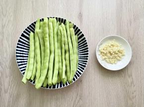 四季豆洗净去筋，大蒜拍碎剁成蒜蓉。
