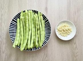四季豆洗净去筋，大蒜拍碎剁成蒜蓉。