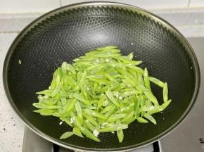 下入四季豆翻炒；
