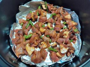 空气炸锅的炸篮上铺一层锡纸，刷一层薄油，然后将串好的牙签串串铺好，尽量不重叠。180度先烤10分钟。