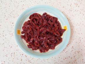 先加入料酒、特级鲜酱油和少许食用油搅拌均匀。