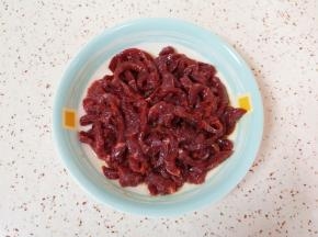 先加入料酒、特级鲜酱油和少许食用油搅拌均匀。