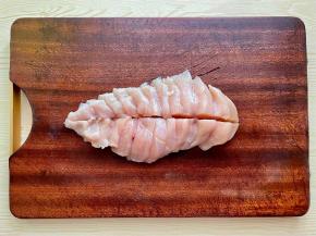 鸡胸肉洗净，斜刀切片，中间再来一刀一分为二。