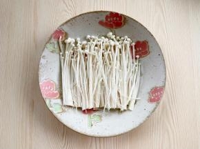 金针菇洗净，去掉根部，摆入盘中。