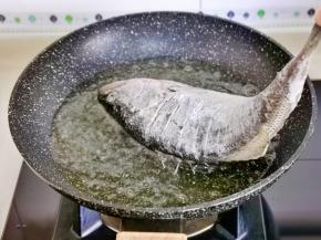 油温7成热时，先把鱼头放入油锅中炸2分钟，如图。