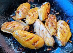 放入糖、一品鲜酱油炒匀再放入鸡翅大火快速翻炒均匀入味