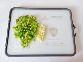 泡椒去籽切成丝，蒜去皮切成末。