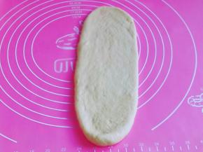 取一块松弛好的面团，用擀面杖擀长舌状。