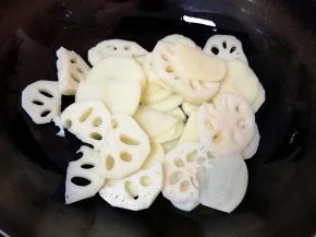 下入土豆和莲藕翻炒至变色。